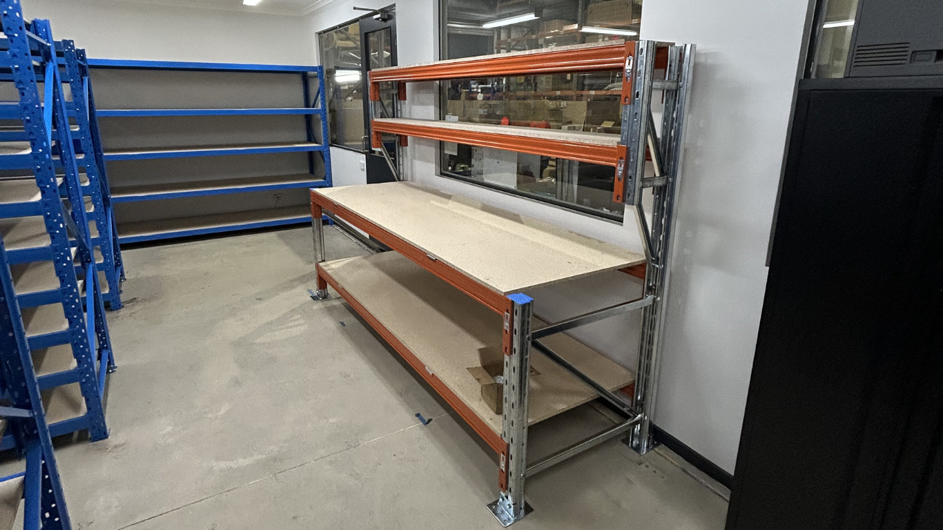 Workstation workbench in a factory workshop with blue longspan shelving