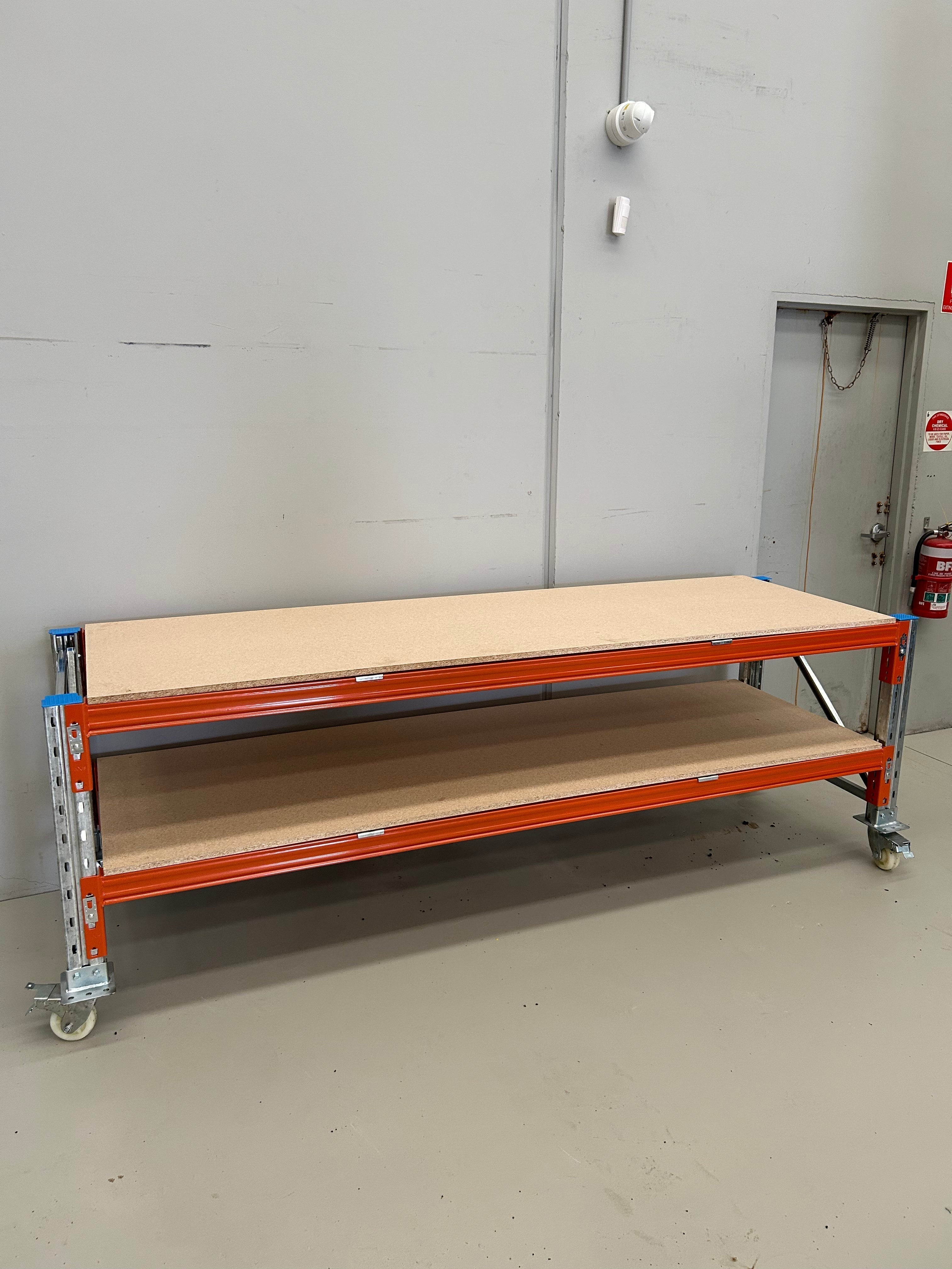 Orange beams, galvanised frame and chipboard workbench in warehouse or workshop