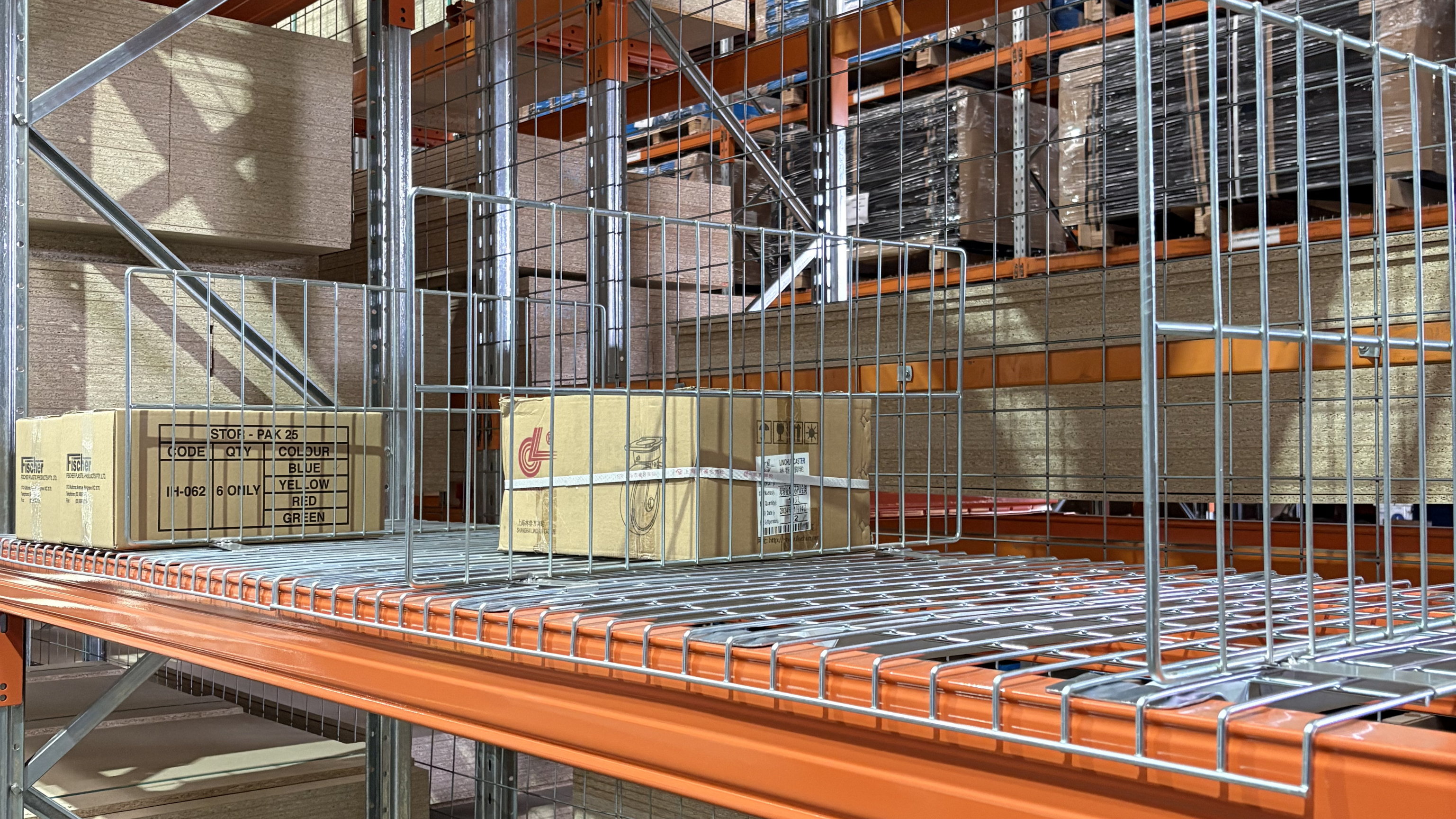 Pallet racking wire mesh dividers installed on mesh decks in a warehouse to separate cartons and improve stock organisation and safety.
