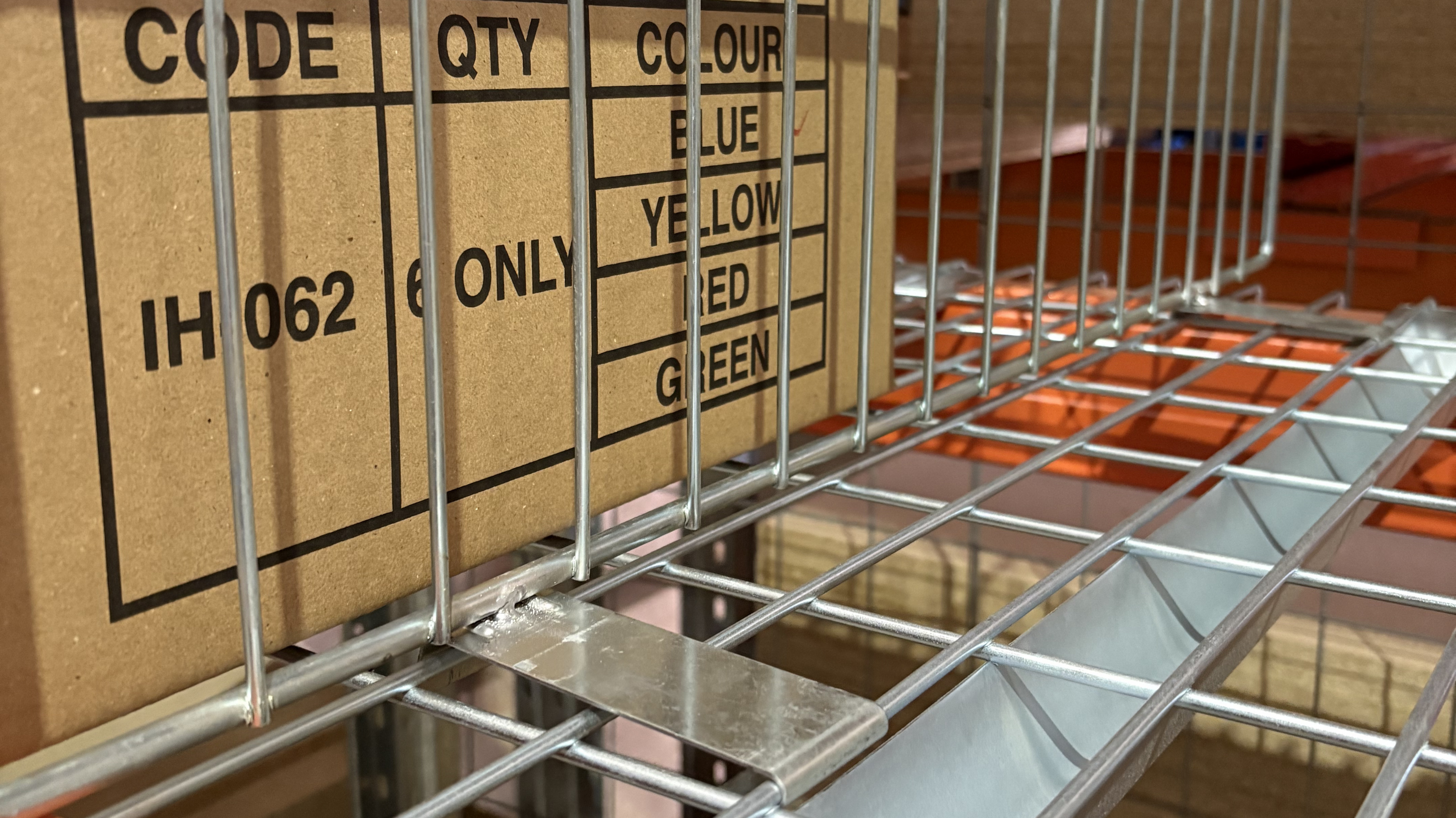 Close-up of a pallet racking wire mesh divider securely mounted onto wire mesh decking for organised warehouse storage separation.