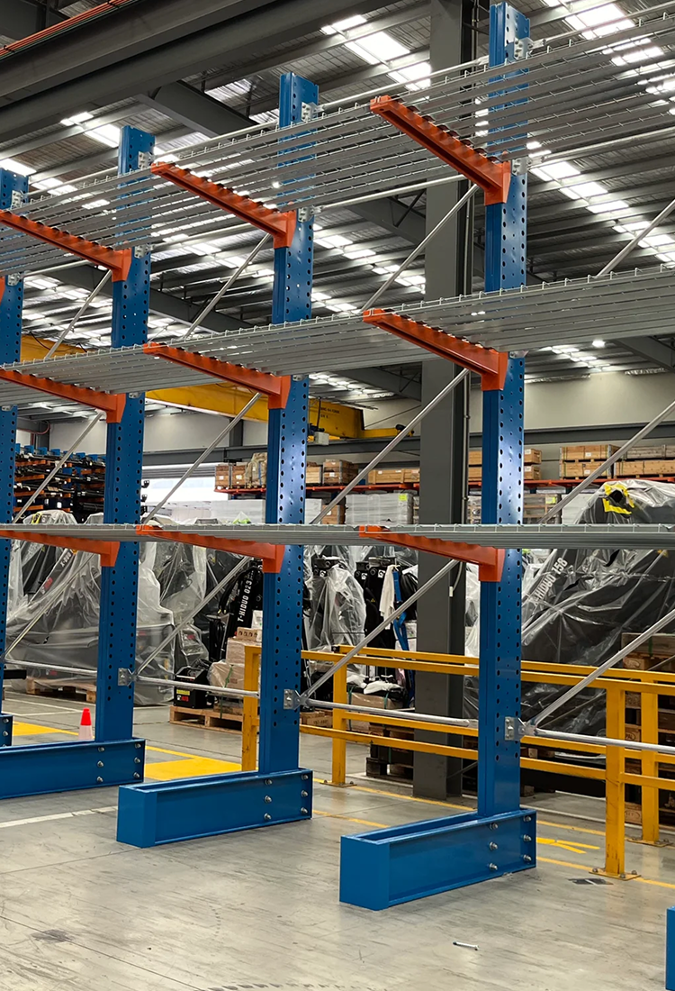 Warehouse storage rack system with blue and orange beams in a large warehouse.